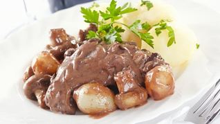 Куриные бедрышки в красном вине с луком, грибами и беконом