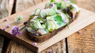 Сельдь на ломте ржаного хлеба с огурцом и черной солью